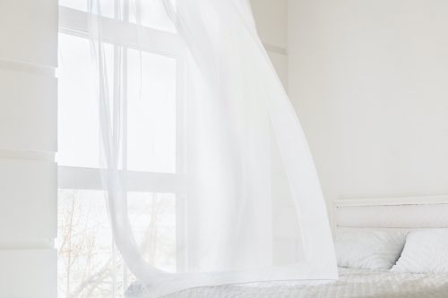 Abstract white waving curtain in white bedroom apartment