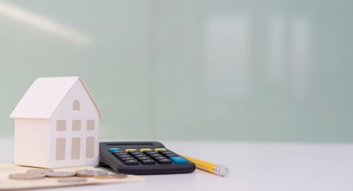 close up house's model on banking account book with calculator, coin and pencil on table for planning of home loan mortgage refinance or retention interest rates , business and financial concept