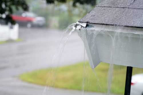 close up on rain flowing from old roof