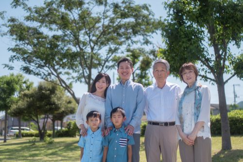 公園で微笑む三世代家族