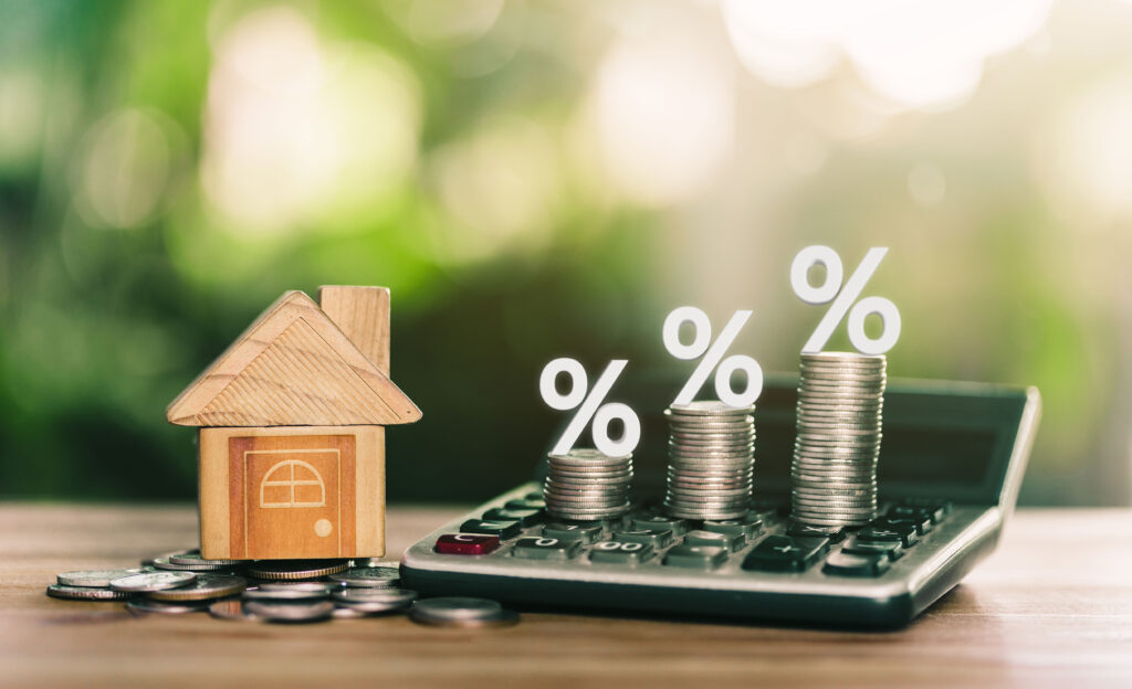 House is placed on the coins. coins on the calculator and has an illustration of interest concept of calculating interest payments. savings money of coins to buy a home concept for property, mortgage.